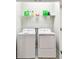 Functional laundry room equipped with a washer, dryer, storage shelving, and ample space for laundry tasks at 6745 Citrus Creek Ln, Tampa, FL 33625