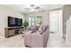 Bright living room boasting a cozy sofa, media center, large windows, and modern staircase for additional floor access at 6745 Citrus Creek Ln, Tampa, FL 33625