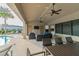 Outdoor lounge area with ceiling fans, TV, sofas and adjacent pool with palm tree at 6745 Citrus Creek Ln, Tampa, FL 33625