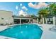 Community pool featuring sun loungers, an outdoor kitchen, and shaded pergola at 6745 Citrus Creek Ln, Tampa, FL 33625