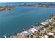 Breathtaking aerial view of a waterfront home with a private dock and in-ground pool at 7060 S Shore S Dr, South Pasadena, FL 33707