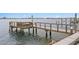 Waterfront view showcasing a dock with wooden railings, offering access to the serene water at 7060 S Shore S Dr, South Pasadena, FL 33707