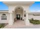 Charming front entrance with a covered archway, seating, and attractive landscaping at 7060 S Shore S Dr, South Pasadena, FL 33707