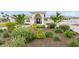 Charming single-story home featuring lush landscaping with tropical plants and a welcoming front entrance at 7060 S Shore S Dr, South Pasadena, FL 33707