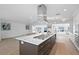 Spacious kitchen features an island with a cooktop, stainless steel vent hood, with an open floorplan at 7060 S Shore S Dr, South Pasadena, FL 33707