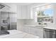 White kitchen features stone countertops, stainless appliances, and a window over the sink area at 7060 S Shore S Dr, South Pasadena, FL 33707