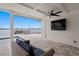 Relaxing covered patio with plush seating, a ceiling fan, and a serene view of the water at 7060 S Shore S Dr, South Pasadena, FL 33707