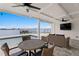 Covered outdoor patio with a dining table, comfortable seating, and stunning waterfront views at 7060 S Shore S Dr, South Pasadena, FL 33707
