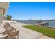 Backyard with a waterfront view, offering lounge chairs and a private dock for easy access to the water at 7060 S Shore S Dr, South Pasadena, FL 33707