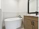 Modern bathroom featuring a sleek soaking tub and stylish vanity with black accents at 7240 Sutton Ln, Sarasota, FL 34240