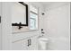 Bathroom features white cabinets, quartz countertops, black fixtures, and tile surround at 7240 Sutton Ln, Sarasota, FL 34240