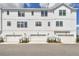 Townhome exterior with white siding, black trim, and multiple garages at 7240 Sutton Ln, Sarasota, FL 34240