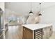 Contemporary kitchen island featuring seating space, a beverage fridge, and sleek pendant lighting at 7240 Sutton Ln, Sarasota, FL 34240