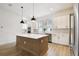 Stylish kitchen featuring white cabinets, stainless steel appliances, and a large island for meal preparation at 7240 Sutton Ln, Sarasota, FL 34240