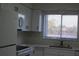 Bright kitchen featuring white cabinetry, appliances, and a window view at 7927 Kosi Palm Pl # 201, Tampa, FL 33615