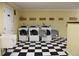 Clean laundry room with black and white floors, utility sink and plenty of washing machines at 7927 Kosi Palm Pl # 201, Tampa, FL 33615