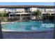 A sparkling community pool with tiled trim and surrounding residential buildings at 7927 Kosi Palm Pl # 201, Tampa, FL 33615