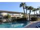 Sunny community pool surrounded by palm trees and condos with balcony views at 7927 Kosi Palm Pl # 201, Tampa, FL 33615