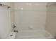 Bathtub with shower and white tiled walls at 7927 Kosi Palm Pl # 201, Tampa, FL 33615