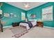 Bright bedroom featuring teal walls, a ceiling fan, and natural light from the windows with a comfortable bed at 795 26Th N Ave, St Petersburg, FL 33704