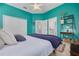 Cozy bedroom showcases teal walls, ceiling fan, and a comfortable bed with stylish decor and ample closet space at 795 26Th N Ave, St Petersburg, FL 33704