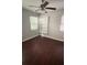 Bedroom with neutral paint, built-in storage, window, ceiling fan, and hard wood floors at 807 E Elm St, Tampa, FL 33604