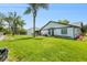 Spacious backyard featuring lush lawn, mature palm trees, and privacy fence at 8135 Golf Club Ct, Hudson, FL 34667