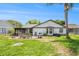 Backyard with a screened-in porch, patio set, palm tree and green grass at 8135 Golf Club Ct, Hudson, FL 34667