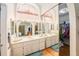 Bathroom featuring dual sinks, lots of light, and mirrors at 8135 Golf Club Ct, Hudson, FL 34667