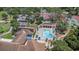 Aerial view of community pool and clubhouse with lounge area and mature landscaping at 8135 Golf Club Ct, Hudson, FL 34667