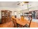 A dining area featuring a wooden table with seating for four, a ceiling fan, and a china cabinet at 8135 Golf Club Ct, Hudson, FL 34667