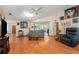 Spacious living room with hardwood floors and comfortable sofa with open access to sun room at 8135 Golf Club Ct, Hudson, FL 34667