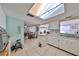 Bright kitchen with white cabinetry, skylight, and tile floors; connecting to dining area at 8702 Congress St, Port Richey, FL 34668