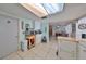 Airy kitchen featuring white cabinetry, tile floors, adjacent to dining area and utility at 8702 Congress St, Port Richey, FL 34668