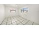 Bedroom with two windows and tile flooring at 8744 Andros Ln, Port Richey, FL 34668