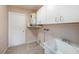 Laundry area with a utility sink, storage cabinets, and access door at 8744 Andros Ln, Port Richey, FL 34668