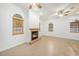 Living room with a charming fireplace, tile floors, and arched windows at 8744 Andros Ln, Port Richey, FL 34668