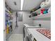 Well-organized laundry room with shelving, tile floor, washer, dryer and ample storage for supplies at 9209 Seminole Blvd # 156, Seminole, FL 33772