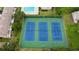 Aerial view of three well-maintained blue tennis courts at 9209 Seminole Blvd # 156, Seminole, FL 33772
