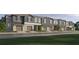 Row of new townhomes with garages, gray and stone exteriors, and well-maintained landscaping at 9333 Bonita Mar Dr, Parrish, FL 34219