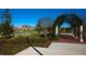Picturesque garden arbor with a view of charming homes and lush landscaping beyond at 9467 Raised Tulip Ln, Land O Lakes, FL 34637