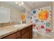Bright bathroom features a modern vanity with a large mirror, and a solar system themed shower curtain at 9520 Trumpet Vine Loop, Trinity, FL 34655
