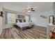 Spacious bedroom with a ceiling fan, natural light, and stylish wood-look flooring at 9520 Trumpet Vine Loop, Trinity, FL 34655