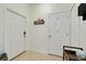 Bright entryway with neutral tile floors, white walls, white doors, and a convenient coat rack at 9520 Trumpet Vine Loop, Trinity, FL 34655
