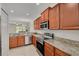 Modern kitchen with stainless steel appliances, granite countertops, tile flooring, and stylish cabinetry at 9520 Trumpet Vine Loop, Trinity, FL 34655