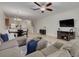 Open-concept living space with tile floors, a comfortable sectional, and seamless flow to the kitchen and staircase at 9520 Trumpet Vine Loop, Trinity, FL 34655