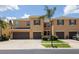 Inviting townhome with a two-car garage, manicured lawn, and a charming palm tree in a well maintained community at 9520 Trumpet Vine Loop, Trinity, FL 34655