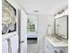Bright bathroom leading to bedroom with a new vanity, framed mirror and tile floors at 9907 Island Harbor Dr, Port Richey, FL 34668