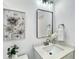 Modern bathroom featuring a white vanity, stylish mirror, and elegant floral artwork at 9907 Island Harbor Dr, Port Richey, FL 34668