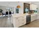 Open-concept kitchen with white cabinets, stainless steel appliances, and a view of the dining area at 9907 Island Harbor Dr, Port Richey, FL 34668